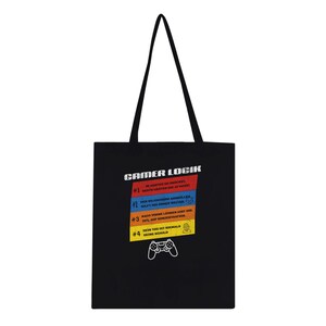 Op de afbeelding: Een zwarte tote bag met de witte tekst GAMER LOGIK bovenaan. Daaronder staan vier gekleurde horizontale balken in rood, blauw, oranje en geel met genummerde Duitse tekst en iconen. Onderaan staat een witte omtrek van een gamecontroller.