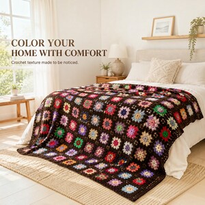 Puede incluir: Una manta de ganchillo con una base marrón oscuro y un patrón repetitivo de cuadrados de la abuela multicolores en tonos rosa, azul, verde, amarillo y morado. El texto "COLOR YOUR HOME WITH COMFORT" y "Crochet texture made to be noticed" es visible.