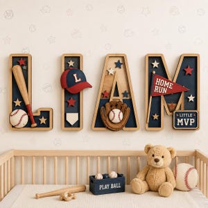 Op de afbeelding: Vier grote houten letters die LIAM spellen, versierd met honkbalthema's waaronder een knuppel, bal, handschoen, pet en een wimpel met de tekst HOME RUN en LITTLE MVP. Daaronder een blauwe krat met het opschrift PLAY BALL, een teddybeer en een honkbal.