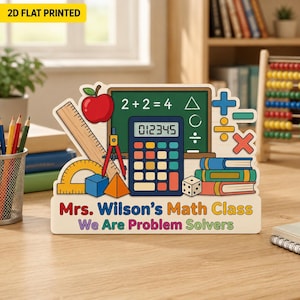 May include: A flat, decorative sign featuring a colorful illustration of school supplies including a chalkboard with 2+2=4, a calculator, a red apple, books, and geometric shapes. The text reads Mrs. Wilson's Math Class We Are Problem Solvers.