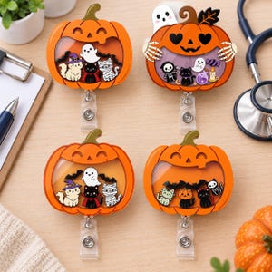 May include: Four orange pumpkin-shaped badge reels featuring clear shaker windows filled with miniature Halloween-themed charms including ghosts, cats, bats, skeletons, and mummies. Each acrylic badge holder has a retractable cord and clip.