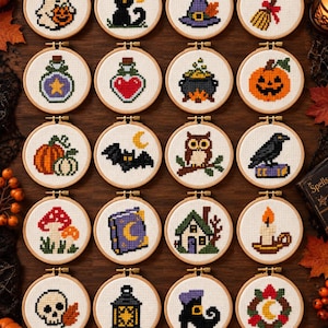 May include: A collection of twenty circular wooden embroidery hoops, each featuring a unique Halloween-themed cross-stitch design on white fabric. The motifs include a ghost, black cat, witch hat, broom, potion bottles, cauldron, pumpkin, bat, owl, raven, mushrooms, spellbook, house, candle, skull, lantern, boot, and a wreath.