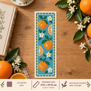 Peut inclure: Un motif de point de croix rectangulaire représentant des oranges, des tranches d'orange et des fleurs blanches sur un fond bleu avec une bordure jaune et verte. La taille finie est de 5,93 par 19,76 cm, pour une toile Aida 18 points.
