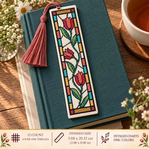 Può includere: Un segnalibro rettangolare a punto croce con un motivo in stile vetrata raffigurante tulipani rossi con steli e foglie verdi, bordato da forme geometriche blu e gialle. Include una nappa color rosa antico e misura 5,08 x 20,32 cm.
