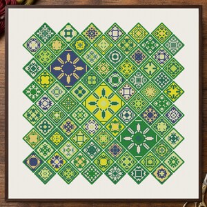 May include: A square cross-stitch embroidery piece featuring a grid of diamond-shaped patterns in shades of green, yellow, and dark blue. The design consists of numerous small, intricate geometric motifs arranged in a repeating diamond layout.