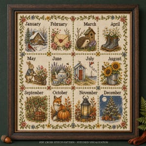May include: A framed cross-stitch sampler featuring twelve seasonal vignettes labeled January through December. Each square depicts thematic imagery including a winter cabin, spring flowers, summer sunflowers, and a decorated Christmas tree.