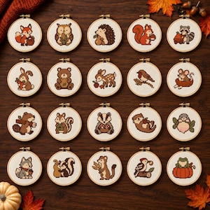 May include: A collection of twenty circular wooden embroidery hoops, each containing a cross-stitch design of a woodland animal. The animals include a fox, owl, hedgehog, squirrel, raccoon, rabbit, bear, deer, bird, mouse, beaver, chipmunk, badger, otter, mole, wolf, skunk, weasel, woodpecker, and frog.