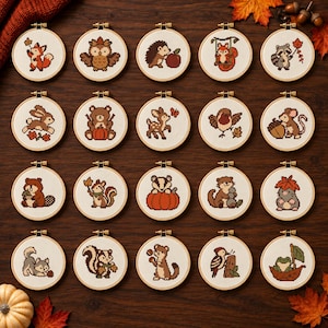 May include: Twenty circular wooden embroidery hoops containing cross-stitch designs of various woodland animals including a fox, owl, hedgehog, squirrel, raccoon, rabbit, bear, deer, bird, mouse, beaver, badger, otter, wolf, skunk, and frog.