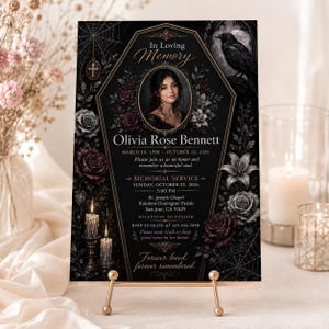 Op de afbeelding: Een zwarte herdenkingskaart met een doodskistvormig kader, een portret van Olivia Rose Bennett en tekst over de herdenkingsdienst op 23 oktober 2026. Het ontwerp bevat illustraties van donkere rozen, een raaf en spinnenwebben.