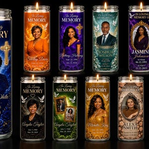 May include: A collection of nine cylindrical glass memorial candles, each featuring a lit wick, a portrait of a person, the text In Loving Memory, a name, and dates. The candles display various background colors including blue, orange, purple, and green.