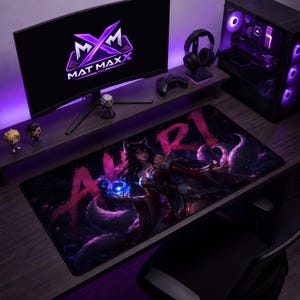 Puede incluir: Una alfombrilla de escritorio rectangular con un gráfico oscuro en tonos púrpuras de un personaje con orejas de zorro que sostiene un orbe azul brillante, con el texto AHRI impreso en grandes letras rosas desgastadas sobre un escritorio de madera.