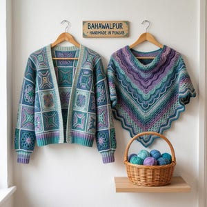 May include: A crochet cardigan made of blue, teal, and purple squares and a matching triangular shawl in similar colors hang on wooden hangers. A wooden sign reads BAHAWALPUR - HANDMADE IN PUNJAB. A wicker basket holds several balls of yarn.
