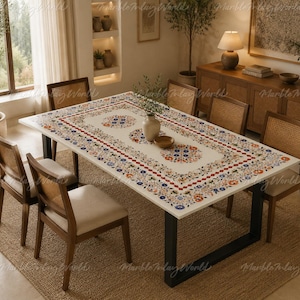 May include: A rectangular dining table with a white marble top featuring an intricate floral inlay pattern in orange, blue, and green. The table is supported by a black metal frame and is surrounded by six wooden chairs with cane backrests.
