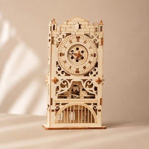 Puede incluir: Un reloj modelo de madera clara con intrincados detalles cortados con láser, una esfera circular con números romanos y un mecanismo de engranajes central. La estructura incluye una base arqueada decorativa y un diseño tipo torre.