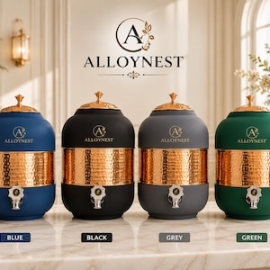 May include: Four cylindrical water dispensers with matte finishes in blue, black, grey, and green. Each features a central hammered copper band, a matching copper lid with a finial, and a silver spigot. The brand name ALLOYNEST is printed on each.