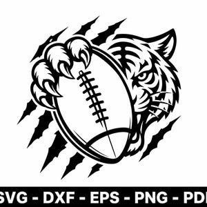 May include: A black and white graphic illustration featuring a tiger head with sharp claws gripping an American football. The design includes claw marks in the background and the text SVG - DXF - EPS - PNG - PDF at the bottom of the image.