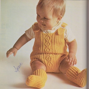 May include: A yellow knitted baby romper with a cable knit pattern and matching socks. The romper has straps and a button closure.
