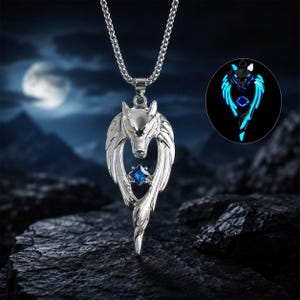 May include: A silver-toned metal pendant necklace featuring a stylized wolf head design with wings and a central square-cut blue gemstone. The pendant is suspended from a silver chain, and an inset shows the wolf design glowing with blue light.