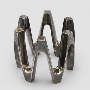 May include: A white ceramic mug with a black handle and the text "But First, Coffee" in a black, handwritten-style font. The mug is on a white surface.