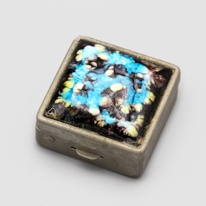 May include: A set of three ceramic mugs with a speckled, matte finish. The mugs are in shades of cream, light gray, and dark gray. Each mug has a simple, minimalist design and a rounded handle. Perfect for coffee or tea.