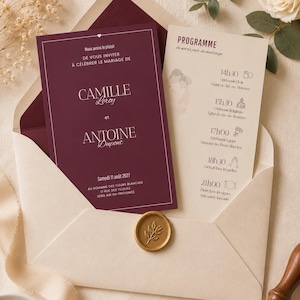 Peut inclure: Un faire-part de mariage bordeaux avec du texte blanc et une enveloppe crème assortie. L'invitation présente les noms Camille Leroy et Antoine Dupont, datée du 11 août 2027, accompagnée d'une carte programme et d'un sceau en cire doré.