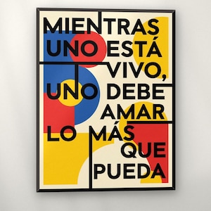 May include: A rectangular wall art print in a black frame featuring the Spanish text MIENTRAS UNO ESTÁ VIVO, UNO DEBE AMAR LO MÁS QUE PUEDA in bold black sans-serif font, set against a cream background with geometric shapes in red, blue, and yellow.