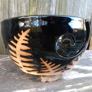 Op de afbeelding: Zwarte keramische garenkom met een varendesigne en een swirl-uitsparing aan de zijkant.