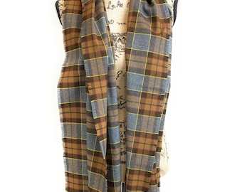 May include: A brown and gray plaid scarf with fringed edges. The scarf is draped over a mannequin.