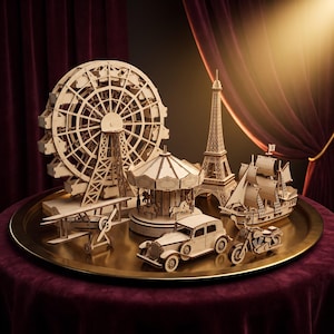 Può includere: Una collezione di modellini in legno chiaro che include una ruota panoramica, una giostra, la Torre Eiffel, un veliero, un biplano, un'auto d'epoca e una motocicletta, il tutto disposto su un grande vassoio rotondo color oro metallizzato.