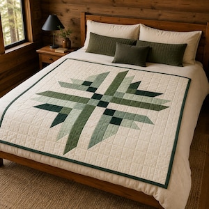 May include: A square quilt featuring a geometric star pattern in shades of forest green, sage, and cream. The quilt has a grid-stitched texture and a dark green border, displayed flat on a bed with cream-colored bedding and two dark green pillows.