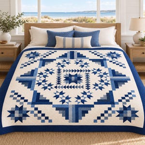 Op de afbeelding: Een bedsprei met een geometrisch patroon in marine- en lichtblauwe tinten op een crèmekleurige achtergrond. Het ontwerp bevat stermotieven en getrapte blokpatronen, afgewerkt met een effen marineblauwe rand die het geheel omlijst.