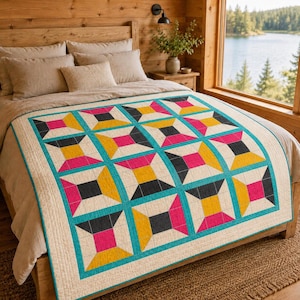 May include: A quilt featuring a geometric pattern of squares and trapezoids in shades of hot pink, mustard yellow, and charcoal grey, all outlined with a bright turquoise border on a cream-coloured background, draped over a bed with neutral pillows.