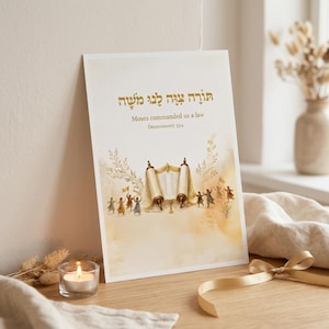 May include: A vertical rectangular print featuring a central illustration of an open Torah scroll flanked by figures in motion. The text reads in Hebrew, followed by the English phrase Moses commanded us a law and Deuteronomy 33:4 in gold.