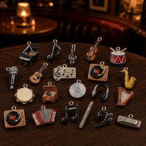 May include: A collection of miniature music-themed charms featuring a black piano, musical notes, a violin, a drum, a microphone, a guitar, a staff with notes, a record player, a saxophone, a tambourine, a CD, headphones, a harp, an accordion, a flute, and a harmonica.