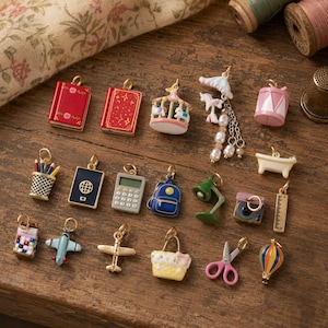 May include: A collection of miniature metal charms featuring various objects including two red books, a carousel, a drum, a pencil holder, a passport, a calculator, a backpack, a desk lamp, a bathtub, a camera, a ruler, a plane, a basket, scissors, and a hot air balloon.