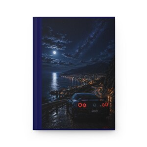 Peut inclure: Un carnet à couverture rigide avec une tranche bleu foncé et une illustration sur la couverture montrant une Nissan GT-R noire garée sur une route côtière la nuit. L'image présente une pleine lune, un ciel étoilé et une côte urbaine lumineuse.