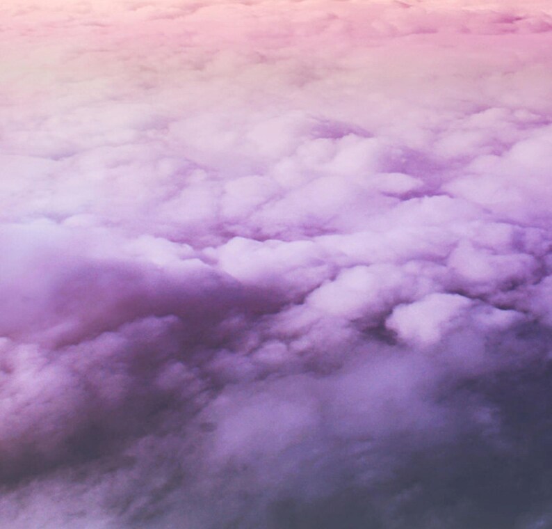 May include: A close-up view of a sky filled with fluffy white clouds, with a gradient of pink and purple hues.