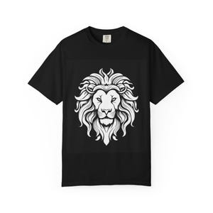 Puede incluir: Una camiseta negra de manga corta con una gran ilustración gráfica blanca centrada de una cabeza de león con una melena detallada y fluida. El diseño está situado en la zona del pecho de la camiseta, que tiene un cuello redondo estándar.