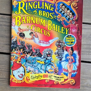 May include: A white ceramic mug with a black handle and the text "But First, Coffee" in a black, bold font. The mug is on a white surface.