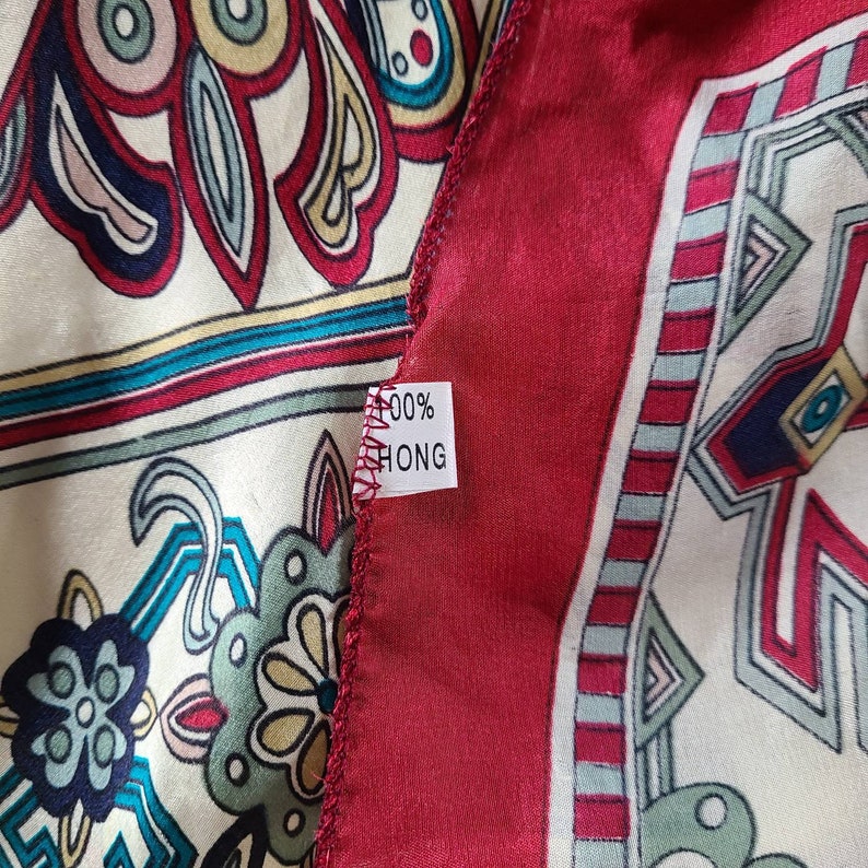 May include: A close-up of a red and white patterned fabric with a white tag that says "100% HONG".