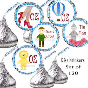 May include: Hershey's Kiss stickers featuring characters from The Wizard of Oz. Designs include Dorothy's ruby slippers, a hot air balloon, the Scarecrow, the Tin Man, and the Cowardly Lion. The text "Kiss Stickers Set of 120" is also included.