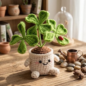 Peut inclure: Une plante crochetée avec des feuilles vert vif et une petite coccinelle rouge, dans un pot en crochet couleur crème arborant un visage souriant avec des yeux noirs et des joues roses, de petits bras et des pieds, sur une surface en bois.