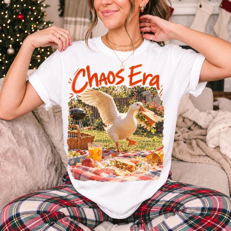 Goose stealing a sandwich from a picnic blanket, 90s film photo style, text "Chaos Era"