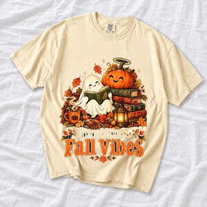 Smiling pumpkin with a halo beside a stack of books and a lantern, text "Lord, Give Me Fall Vibes", retro fall illustration