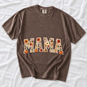 Arched varsity word MAMA filled with fall flowers and acorns in cream, rust and mustard