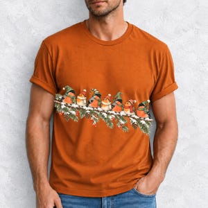 Watercolor bullfinches and robins in elf hats and scarves on a snowy pine branch
