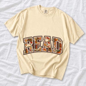 Arched varsity word READ filled with tiny books and autumn leaves in cream, rust and mustard