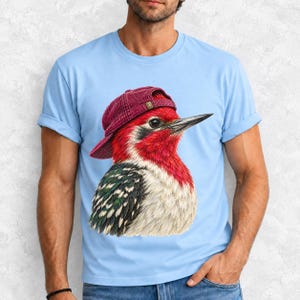 Colored-pencil red-headed woodpecker in side profile wearing a backwards corduroy cap, funny birder t-shirt graphic