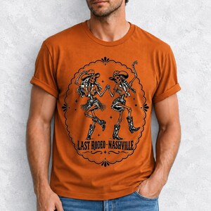 Two cowgirl skeletons in hats line dancing in a starry frame with the text Last Rodeo Nashville