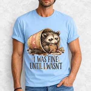 Tired opossum inside a tipped paper coffee cup with the text "I Was Fine Until I Wasn't", sepia watercolor sketch